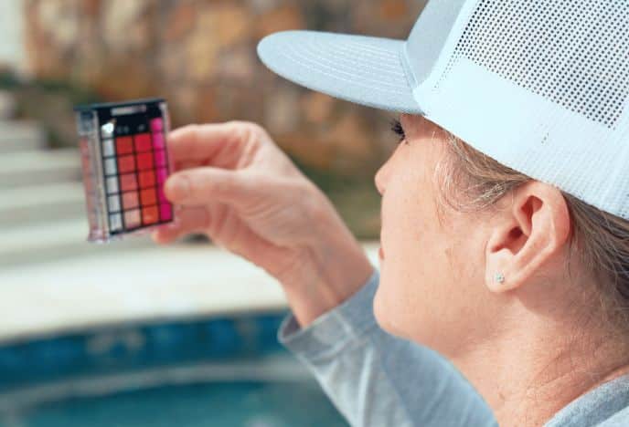 Woman checking the Ph of pool water