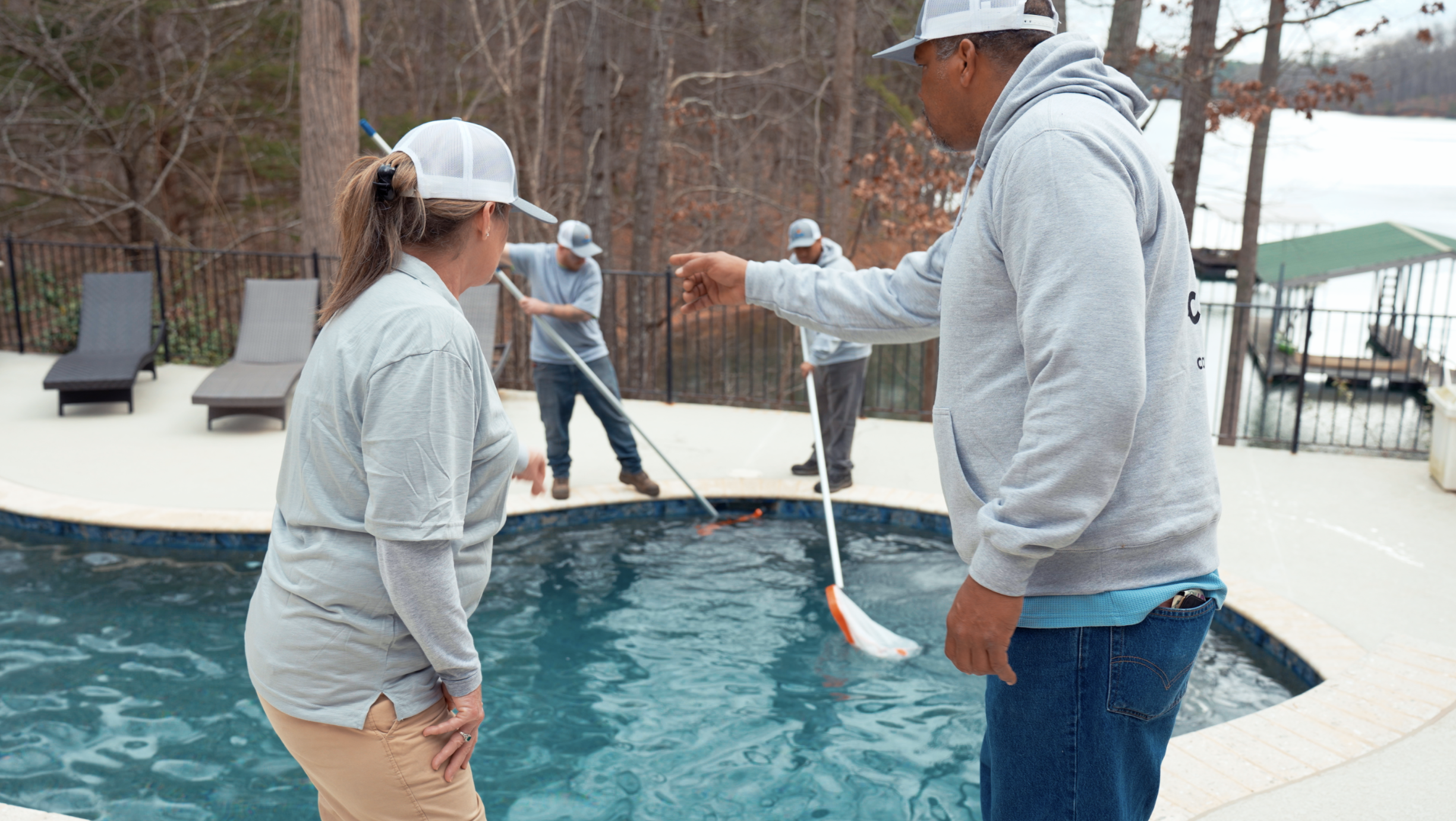 two pool technicians inspecting a job with two technicians in the background